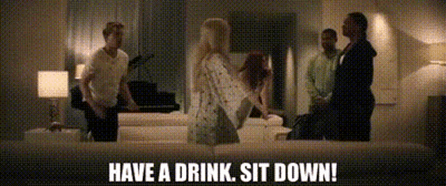 a group of people are standing around a couch with the words `` have a drink , sit down '' written on the bottom .