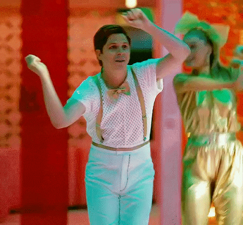 a man in a white shirt and suspenders is dancing on a stage