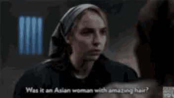 a woman with a scarf on her head is talking to another woman with amazing hair .