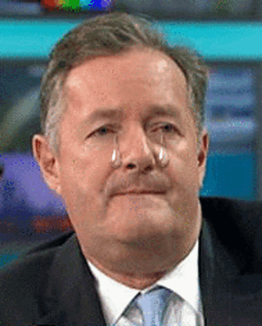 a man in a suit and tie with tears running down his face .