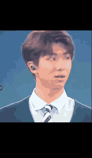 a young man wearing a suit and tie looks surprised