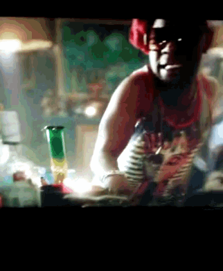 a man in a red tank top smoking a cigarette