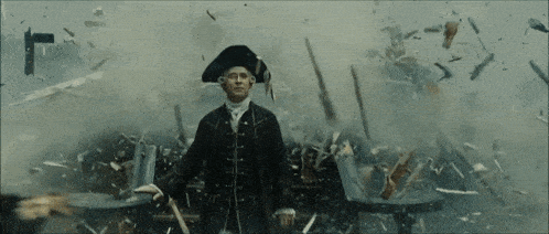 a man in a pirate hat is standing in front of a pile of pieces of furniture