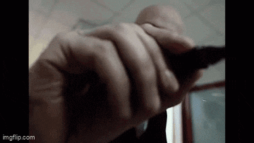 a close up of a person 's hand holding a gun in a dark room .