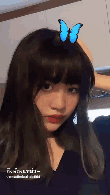 a girl with a blue butterfly on her head is wearing a black top