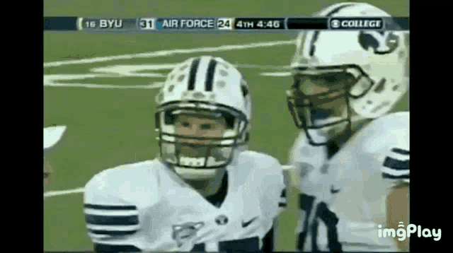 two football players are standing on a field with a score of 16 byu 31 air force 24