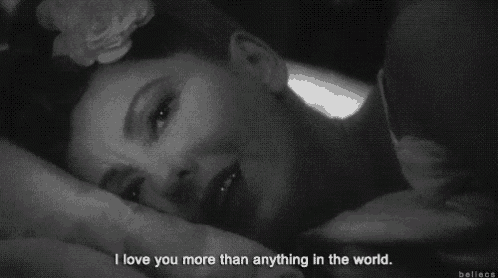a black and white photo of a woman with a flower in her hair and the words i love you more than anything in the world .
