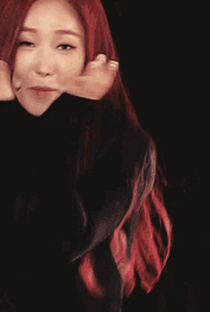 a woman with red hair and white nails covering her mouth with her hand