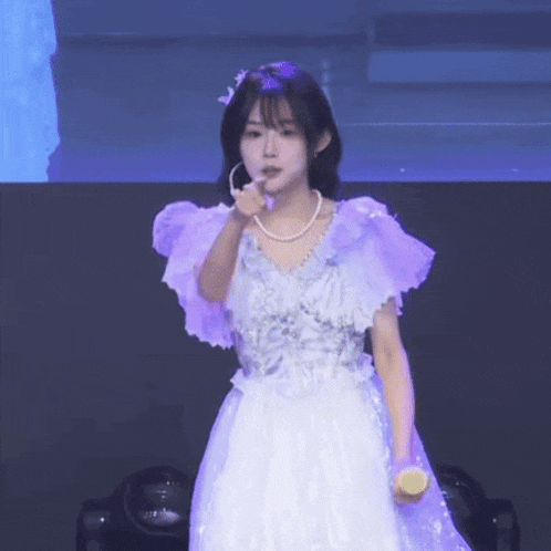 a girl in a purple dress is holding a lemon in her hand .