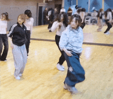 a group of women are dancing in front of a large mirror