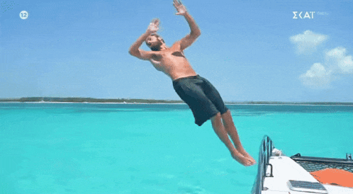 a shirtless man is jumping into the ocean from a boat with the number 12 on the screen