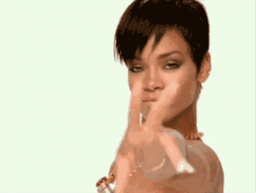 a woman with short hair is pointing at the camera with her hands .