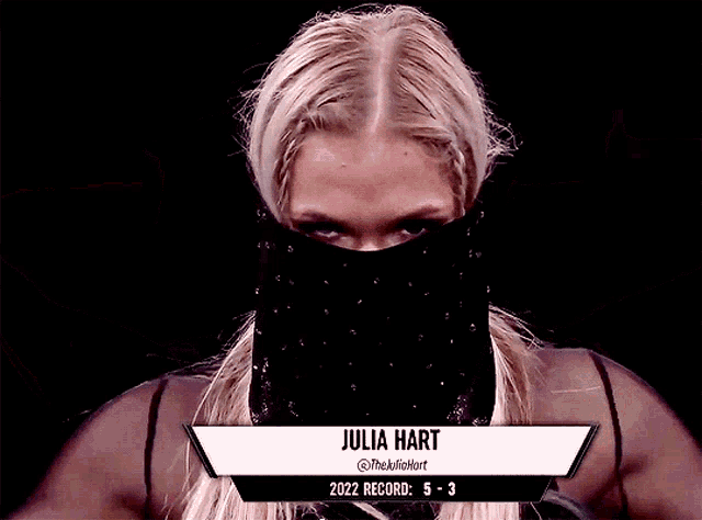 a woman with a black mask on her face and julia hart 2022 record
