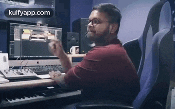 a man is sitting at a desk in front of a computer and a keyboard .