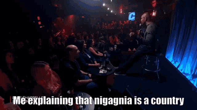 a man is giving a speech in front of a crowd with the caption " me explaining that niagania is a country "