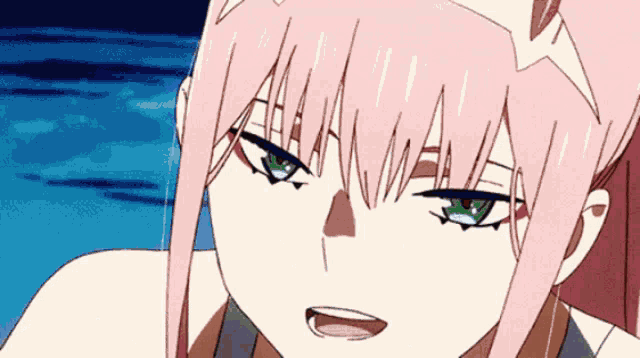 a girl with pink hair and green eyes is looking at the camera .