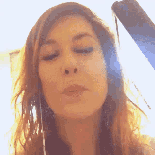a close up of a woman making a funny face with her eyes closed