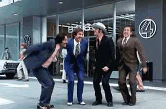 a group of men in suits are dancing in front of a building with a 4 on it