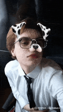 a young man wearing glasses and a dalmatian mask is taking a selfie