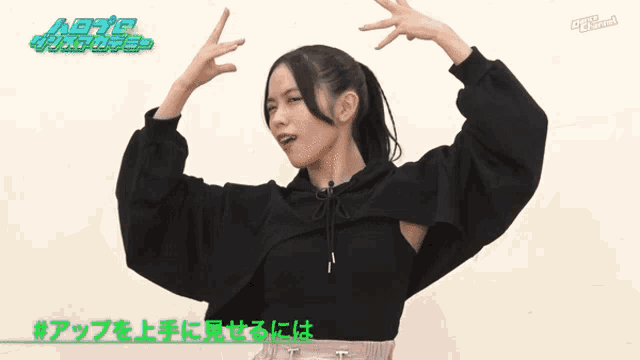 a girl in a black hoodie stands in front of a sign that says ' tokyo channel ' on it