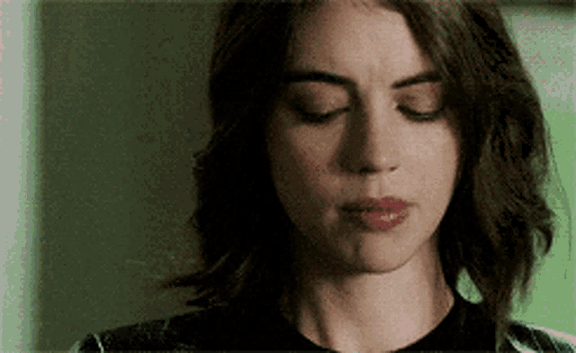 a woman with her eyes closed is wearing a plaid shirt .