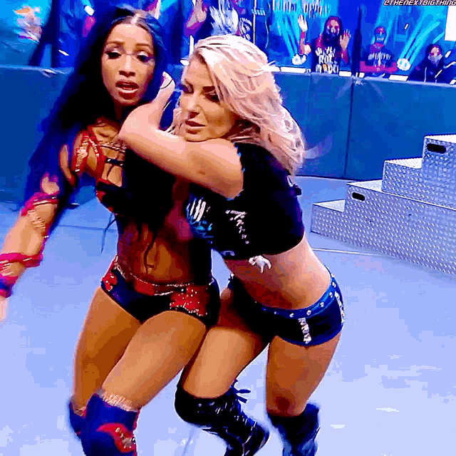two women are wrestling in a ring and one of them is wearing a shirt that says ' smackdown '