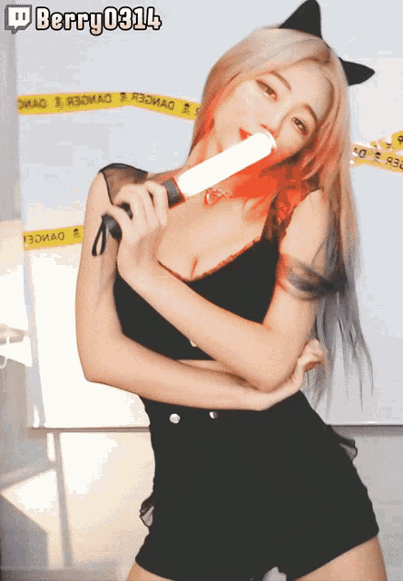 a woman in a black top and shorts is holding a light stick in her mouth with berry 031l4 written on the top right
