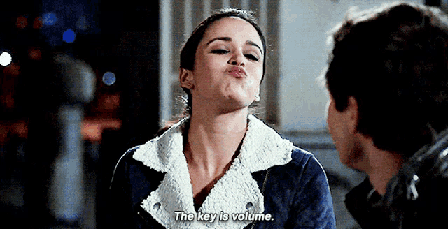 a woman is blowing a kiss at a man and saying the key is volume .
