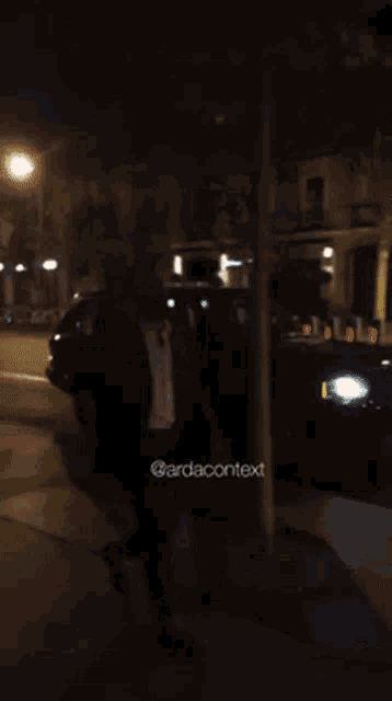 a person is walking down a street at night with a car behind them and the words " @arbacontext " on the bottom