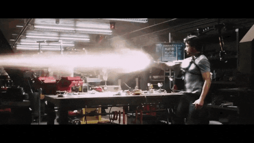 a man is holding a gun that is shooting a light beam
