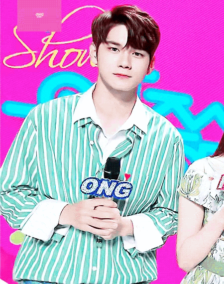 a man in a green striped shirt holds a microphone that says ong