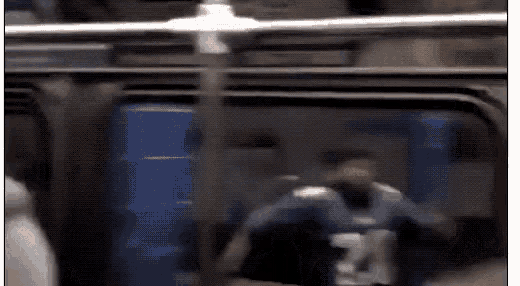 a blurry picture of a person sitting on a subway train .