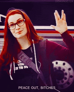 a woman wearing glasses and a shirt that says ' peace out bitches ' on it