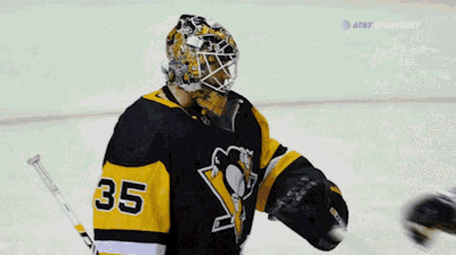 a hockey player with the number 35 on his jersey talks to another player