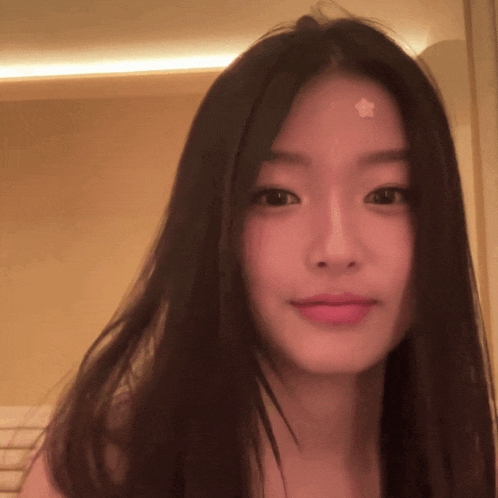 a woman with a star on her forehead looks at the camera