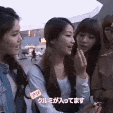 a group of young women are standing next to each other and one of them has a sticker on her face that says " a "