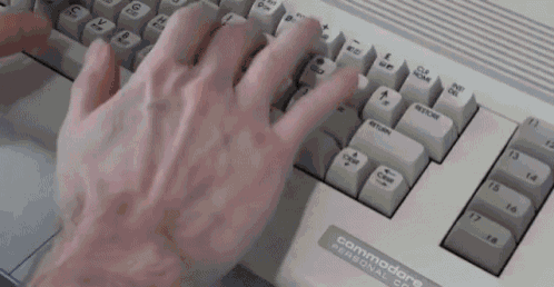 a person is typing on a commodore keyboard