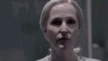 a close up of a grey alien 's face with black eyes .