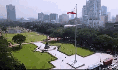 an aerial view of a city park with a flag flying in the foreground