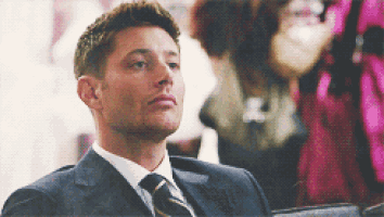 a man in a suit and tie is sitting down