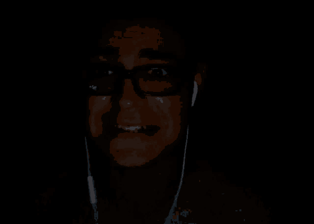 a man making a funny face with his hands in the dark