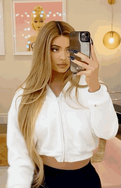 a woman taking a picture of herself with a casetify phone case