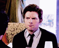 a man in a suit and tie is sitting at a table looking at something