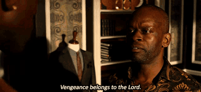 a man says " vengeance belongs to the lord " in front of a suit on a mannequin