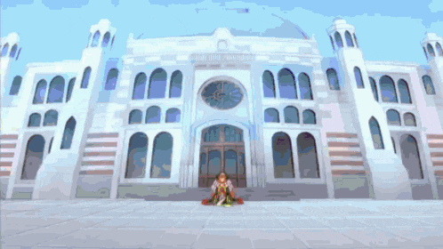 a man sits in front of a large white building with arched windows