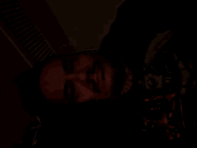 a man with a beard is smiling in a dark room