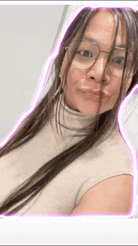 a woman wearing glasses and a turtleneck is smiling