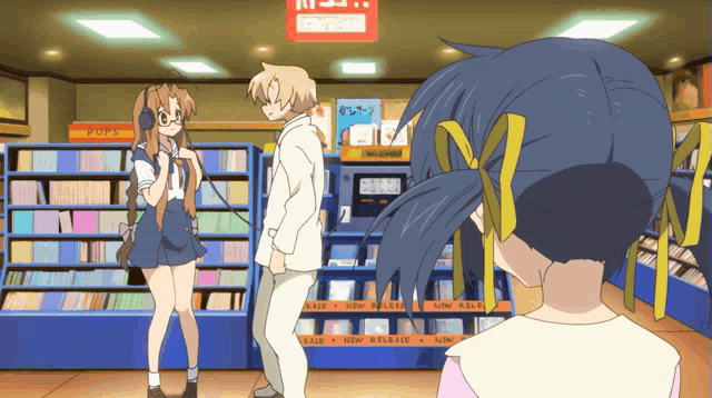 a couple of anime characters standing in front of a shelf that says pop