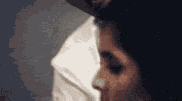 a man and a woman are kissing and the woman is wearing a mask on her face .