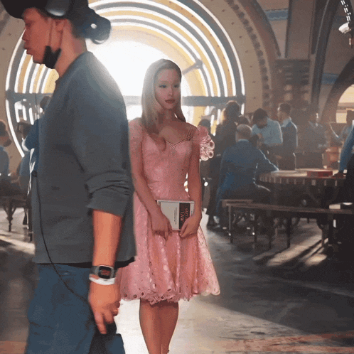a woman in a pink dress is holding a book that says ' i love you '